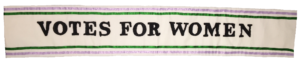A reproduction of a 'Votes for Women!' sash in the Suffrage campaign colours of green, purple and white.