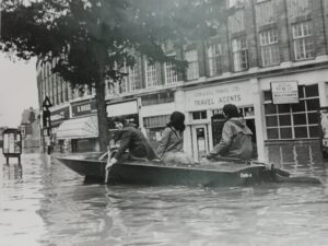People in a boat in Walton Road, Molesey, in the 1968 floods. Copyright H Storey.