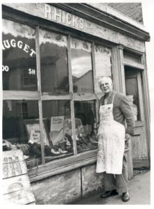 Mr Hicks standing outside his cobblers shop in Bridge Road, East Molesey, 1976.