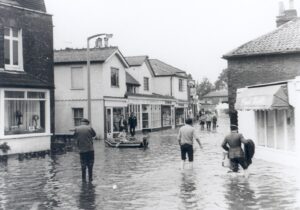Pedestrians in flood water in the Village High Street, Thames Ditton, September 1968.